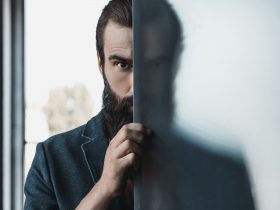 handsome bearded man hiding by frosted glass