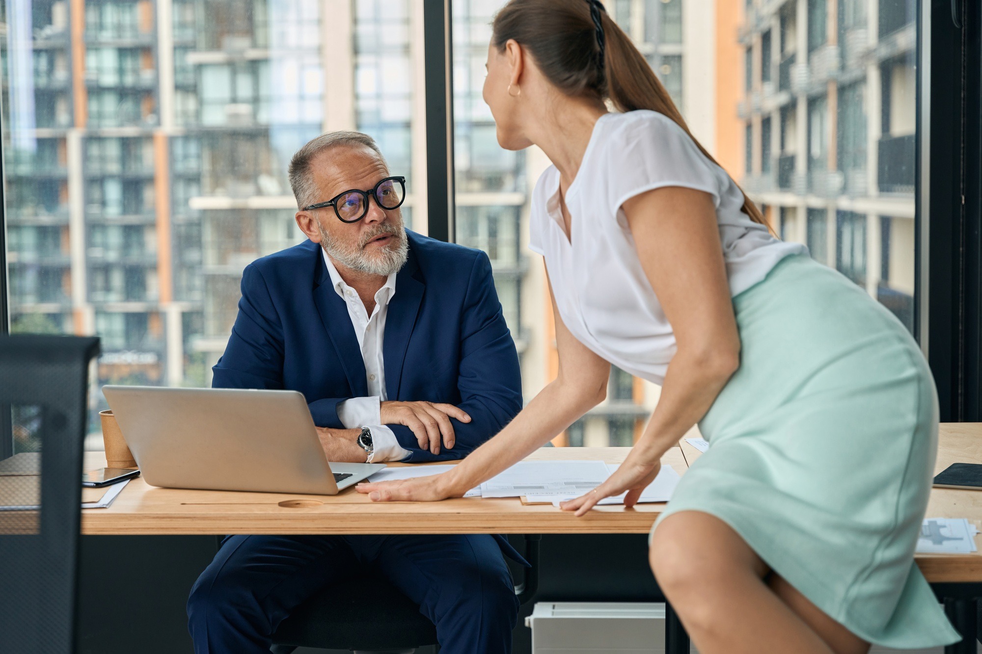 Woman flirting with male boss in office during working day